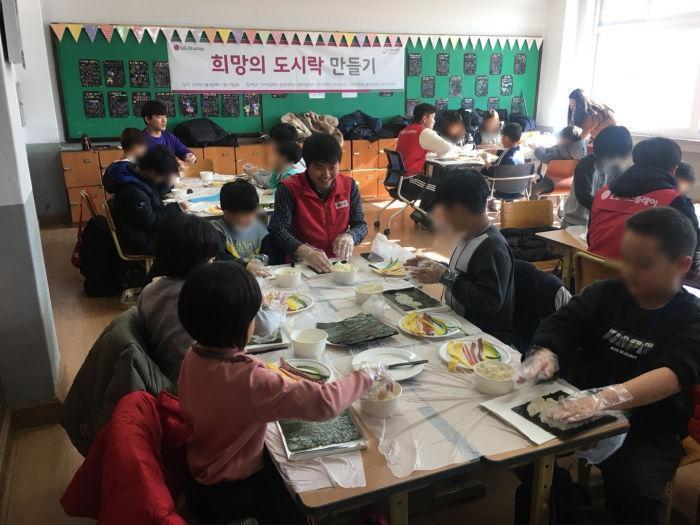 ▲ 지난8일 구미의 한 초등학교에서 LG디스플레이 임직원들이 아이들과 함께 도시락을 만들고 있다.