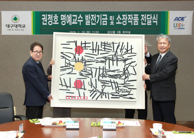 ▲ 지난 29일 전달식에서 권정호 명예교수(왼쪽)가 김상호 총장에게 작품을 전달한 후 기념사진을 찍고 있다.