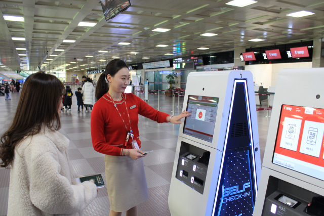 ▲ 티웨이항공이 13일부터 대구공항 국제선 셀프체크인 서비스를 시작했다. 사진은 티웨이항공 직원이 대구공항 이용객에게 셀프체크인 서비스를 설명하는 모습.