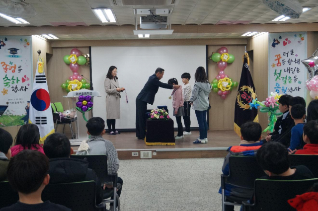 ▲ 이산초등학교 우동하 교장이 학생들에게 메달을 수여하고 있다.