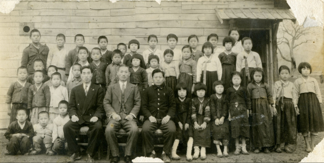 ▲ 칠곡국민학교 교사 시절. 홍영기(앞줄 왼쪽에서 첫째 의자에 앉은 이)는 당시 학생들과 두세살 밖에 나이 차이가 나지 않았다.