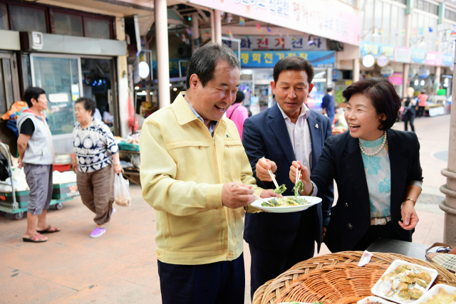 ▲ 김충섭 김천시장이 손태옥(오른쪽) 보건소장과 도시재생사업을 위해 전통시장을 둘러보다 시장 음식 맛을 보고 있다.