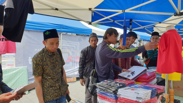 ▲ 미이랏 행사에 참여한 인도네시아인들이 한국 기념품 판매 부스에서 ‘한글 티셔츠’를 구입하고 있다.