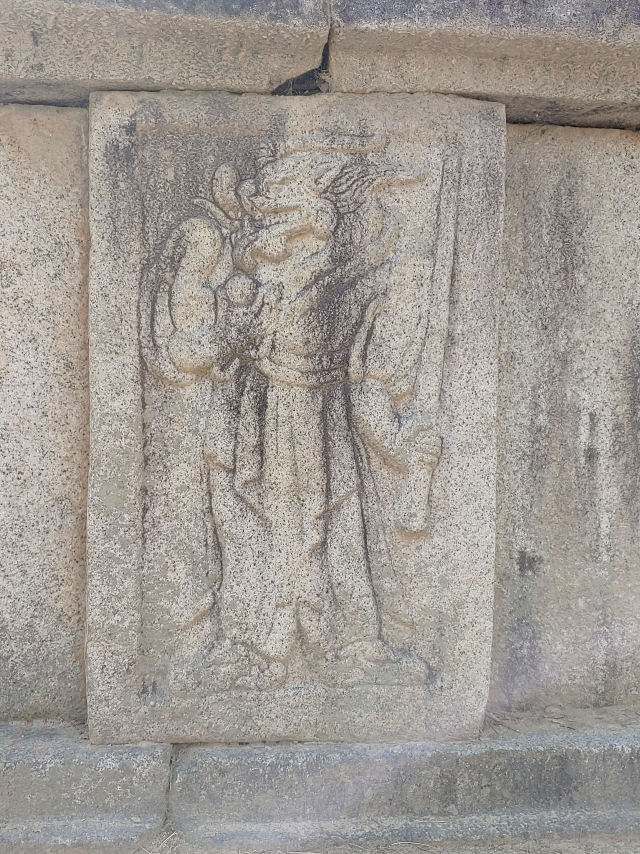 ▲ 김유신 장군의 묘를 둘러싸고 있는 호석에는 12지신상이 두텁게 양각되어 있다. 특이하게 쥐와 용의 신상은 보주를 들고 있다. 평복에 무기와 보주를 들고 있는 용의 신상.