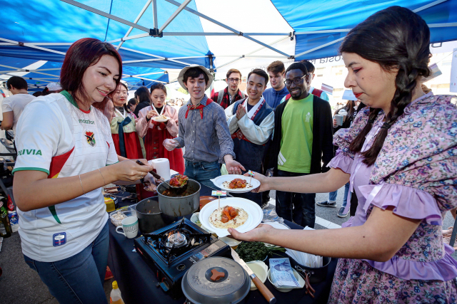 ▲ 지난 10일 열린 세계 음식의 날 행사에서 외국인 유학생이 자국 음식을 선보이고 있다.