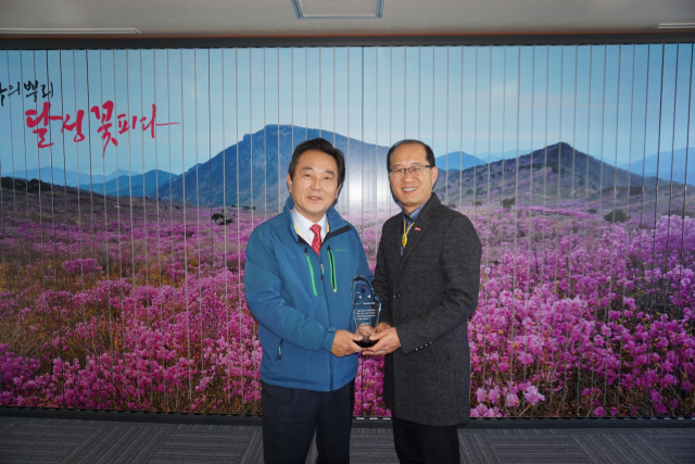 ▲ 김문오 대구 달성군수(왼쪽)가 홍만표 달성군 녹지과장과 함께 수상의 기쁨을 함께하고 있다.