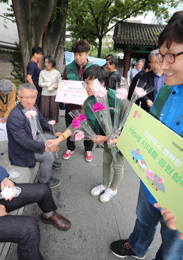 ▲ 서브3-노인의 날인 10월 2일, 청년 단체 회원들이 노인들에게 존경의 의미를 담은 카네이션을 전달하고 있다. 연합뉴스