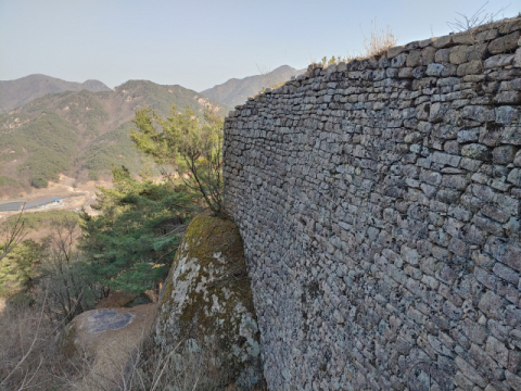 ▲ 동쪽 성문격으로 돌출된 성곽부분은 자연석에 다듬어진 돌을 석축처럼 쌓아 올렸다. 거대한 자연석을 곳곳에 활용해 성이 견고하다.