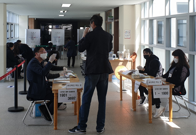 ▲ 대구 동구 신천초등학교에 마련된 신천3동 제2투표소에서 한 유권자가 투표에 앞서 선거사무원에게 본인 확인을 받고 있다.