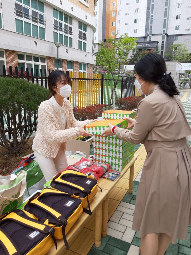 ▲ 대구 포산유치원 교사가 학부모에게 놀이꾸러미를 나눠주고 있다.