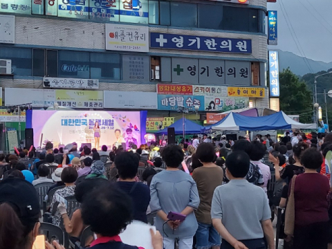 ▲ 구미시 형곡동 형곡시장프라자 주차장에서 지난 9일 열린 대한민국 동행세일 행사장을 찾은 300여 명의 시민이 트롯 가수의 공연을 지켜보고 있다.