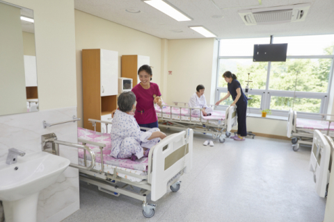▲ 김천노인요양병원은 치매 환자들을 위해 치매안심병원 병실을 4인 1실로 운영한다. 사진은 치매전문 간호사가 환자를 돌보는 모습.