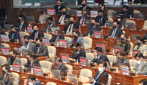 ▲ 국민의 힘 의원들이 9일 오후 좌석 앞에 ‘공수처법 저지’ 등의 피켓을 붙이고 본회의에 참석하고 있다. 연합뉴스
