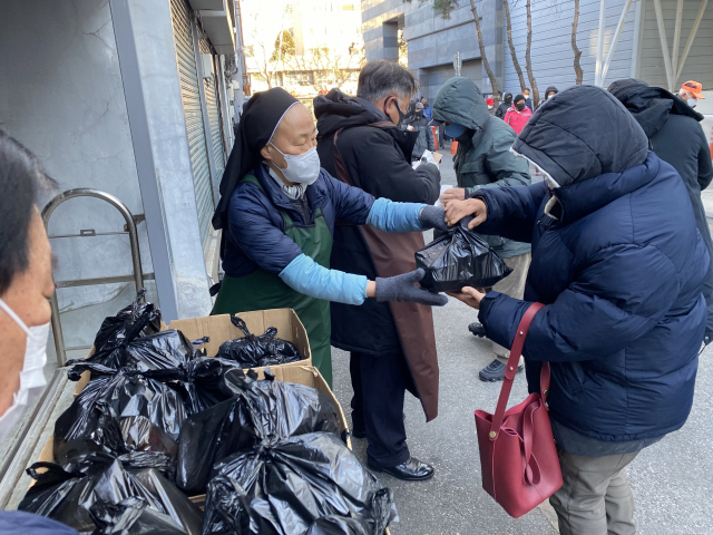 ▲ 지난 15일 오전 대구 중구 요셉의집 아가다 수녀가 노숙자들에게 도시락을 나눠주고 있다.