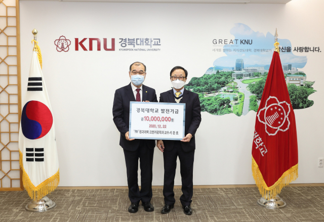 ▲ 서관호 교수(오른쪽)가 홍원화 경북대 총장에게 발전기금을 전달하고 있다