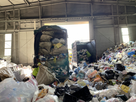 ▲ 수거작업자들이 차량에서 재활용 쓰레기를 수작업으로 꺼내고 있다. 양 옆은 설 연휴 간 배출된 쓰레기로 산처럼 쌓여있다.