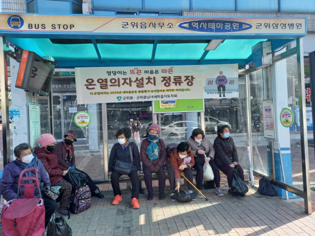 ▲ 군위읍사무소앞 버스정류장에 설치된 온열의자에서 지역 어르신들이 버스를 기다리고 있다.