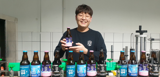 ▲ 별맥 CEO 이형우(34)씨가 별맥 맥주 양조장에서 자사 제품들을 앞에 놓고 환하게 웃고 있다.