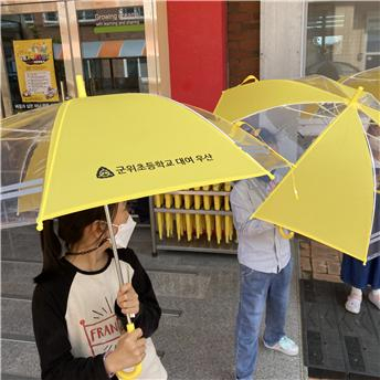 ▲ 군위초 학생들이 학교에 비치된 노란 우산을 들고 하교를 하고 있다.