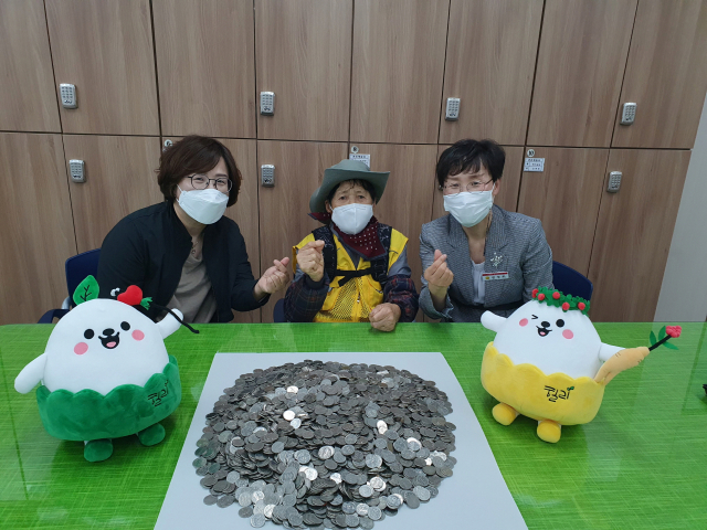 ▲ 영주에서 폐지를 팔아 모은 50만 원을 어려운 사람들을 위해 써 달라고 동전으로 기부한 박 할머니(가운데)의 모습.
