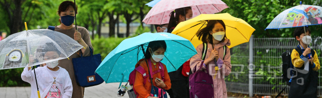 ▲ 소강상태를 보였던 봄비가 다시 내리기 시작한 20일 오전 대구 북구 오페라하우스 인근에서 우산을 쓴 초등학생들이 등교를 하고 있다.