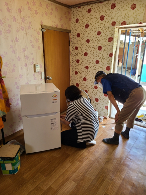 ▲ 군위군청 직원이 지역에 한 어르신 가정을 방문해 냉장고 설치를 도와 주고 있다.