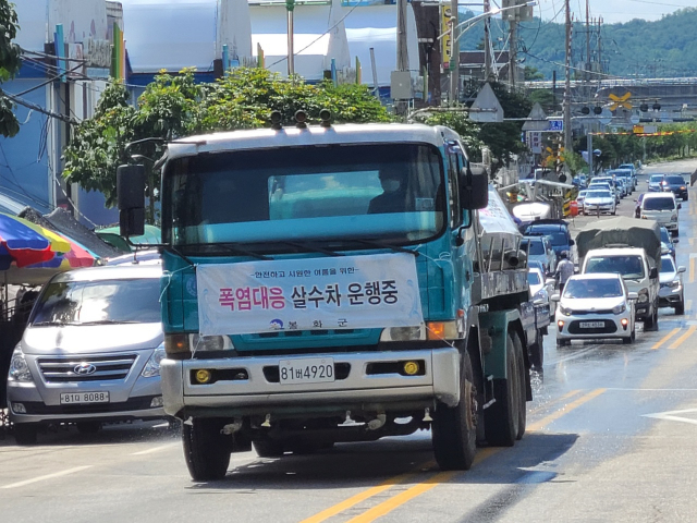 ▲ 폭염으로 인한 피해를 줄이기 위해 봉화군이 살수차를 이용해 주요 도로의 열기를 식히고 있다.