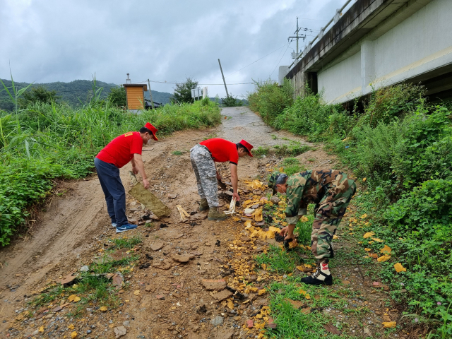 ▲ 해병대 군위군 전우회 회원들이 위천변 일대에서 오물 및 쓰레기 수거 작업을 벌이고 있다.