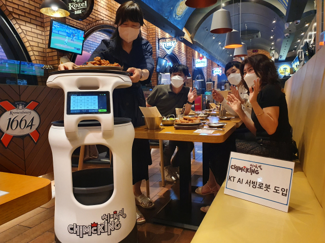 ▲ 대구 치맥킹 침산점에서 고객들이 AI서빙로봇이 배달해 주는 음식을 보고 즐거워하고 있다.