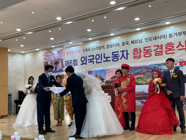 ▲ 구미상공회의소 2층 대강당에서 열린 제6회 외국인노동자 합동결혼식에서 결혼식을 올린 부부들이 상품권을 전달받고 있다.