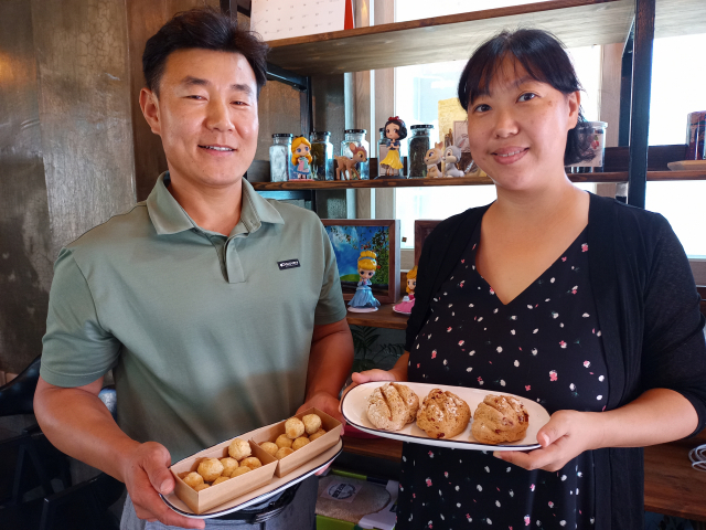 ▲ 김학문 대표가 아내인 윤순옥 공동대표와 함께 경주청년팜 카페에서 우리밀로 만든 빵을 보여주고 있다