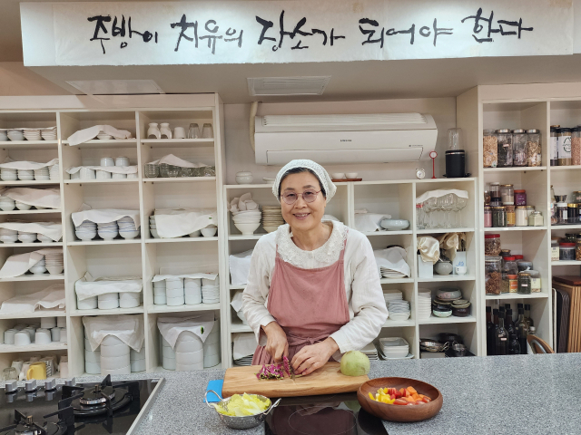 ▲ 주방이 치유의 장소가 돼야 한다는 자신의 요리철학이 게시된 주방에서 식재료를 다듬고 있는 김갑남 대표.