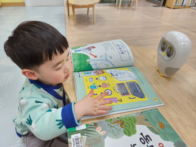 ▲ 대구두류도서관을 방문한 한 어린이가 리딩봇을 이용해 독서를 하고 있다.
