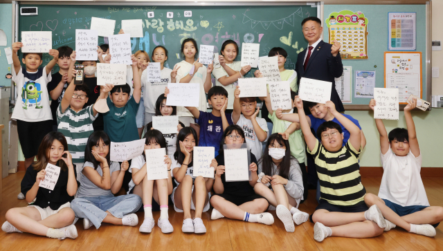 ▲ 왜관초 5학년 학생들이 김재욱 칠곡군수가 작성한 격려의 글을 들고 기념사진을 찍고 있다.