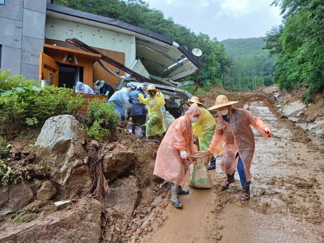 ▲ 봉화군 공무원들이 비가오는 궂은 날씨 속에서도 수해복구 작업을 펼치고 있다.