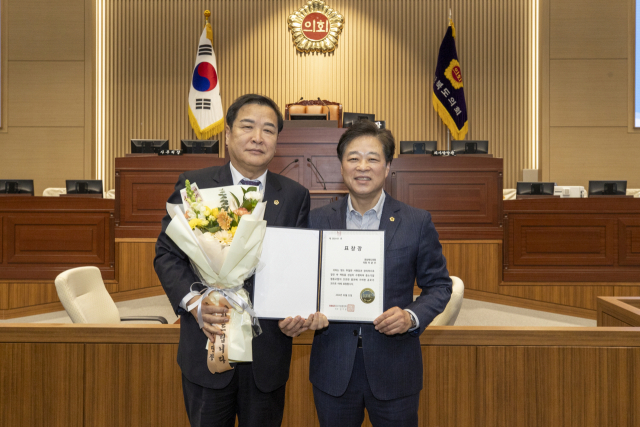 ▲ 이춘우 도의원이 박영서 부의장으로부터 중소기업중앙회장 표창을 전달받고 있다.